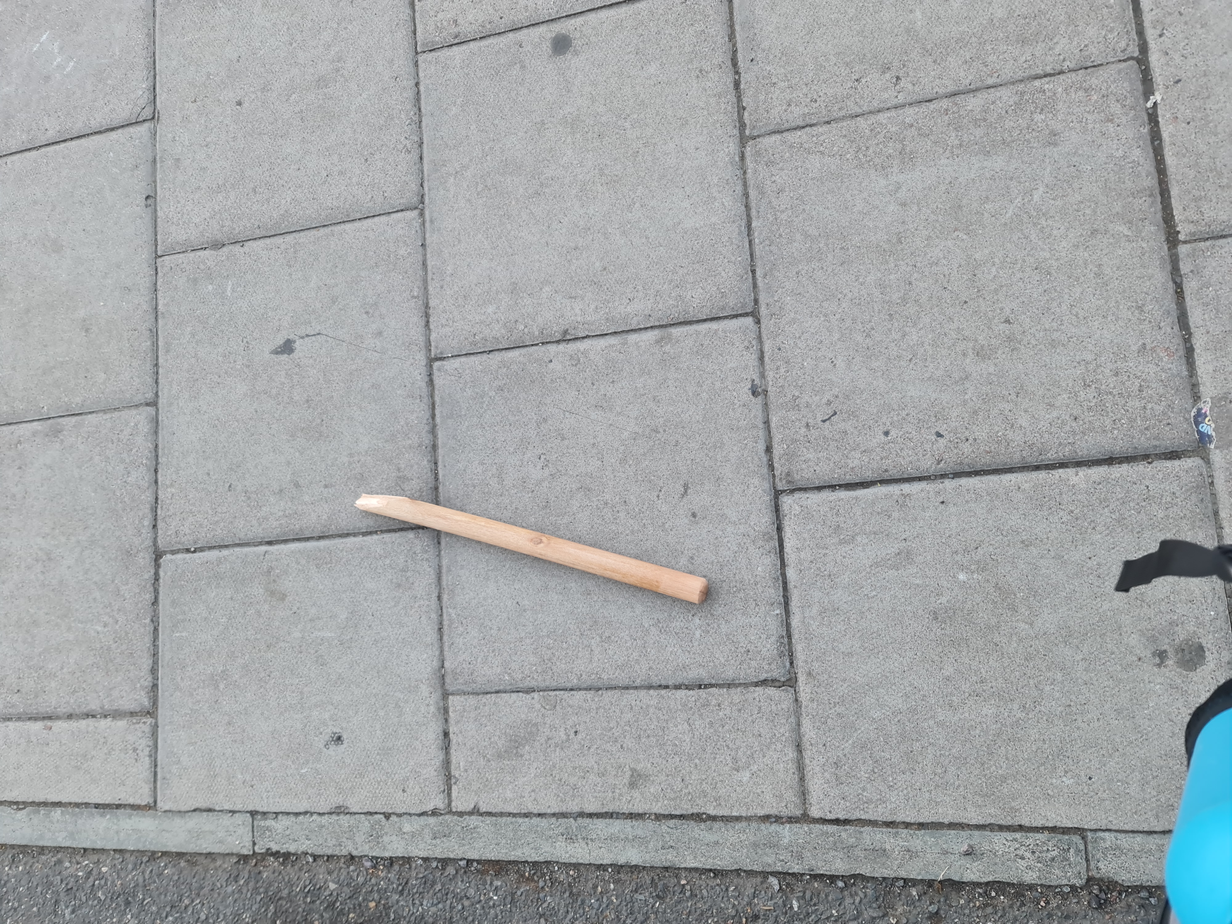 Snapped piece of broom handle lying on the street
