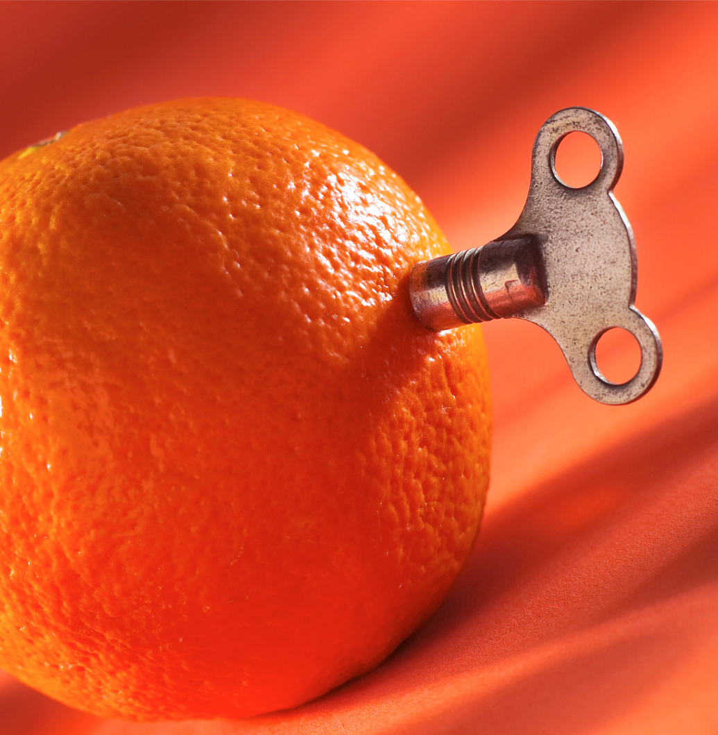An orange with a clockwork key sticking out